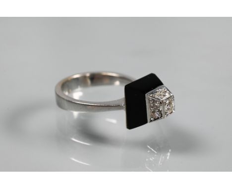 An Art Deco style diamond and onyx ring of geometric form, unmarked white metal set, size K 1/2 