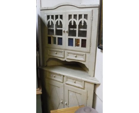 A modern painted pine corner cabinet in the 19th Century manner, the two glazed doors over two drawers and a recess on a base