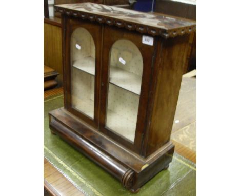 A Victorian mahogany dwarf cabinet, the plain top with carved pediment above two glazed doors, opening to reveal a shelf abov