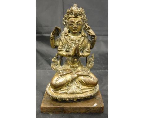 A Tibetan or Sino-Tibetan gilt bronze figure of Avalokitsevara sitting cross-legged on a lotus throne, his hands in various m