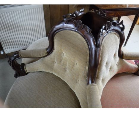 A Victorian walnut framed four section conversation seat with upholstered back, arms and seat on squat cabriole legs to scrol
