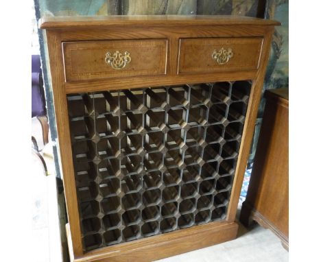 A burr oak wine rack in the 19th Century manner, the top cross-banded and with moulded edge over two drawers and a 64 bottle 