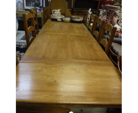 A modern oak farmhouse style kitchen table with two end leaves, together with a set of eight matching ladder back dining chai