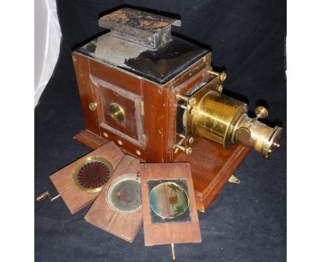 An Ensign mahogany cased and brass mounted magic lantern, together with three moveable magic lantern slides and a "Jaynay Eas
