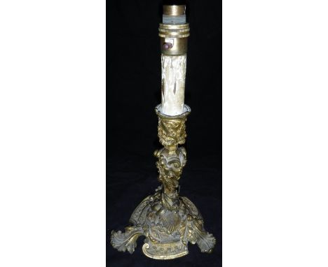A 19th Century gilt brass candlestick in the Rococo taste with C scrolling foliate, shell and dragon decoration, the three fe