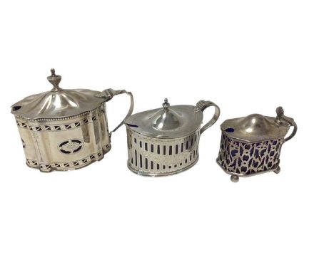 Three silver mustards, including a Victorian oval silver pierced mustard pot with fluted handle and blue glass liner, Chester