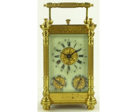 A French brass cased carriage clock with multiple dials showing day, date and month, ornate gilt brass case with fretwork fri