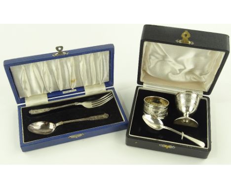 A 3-piece silver egg cup, napkin ring and spoon set and cased silver fork and spoon, (2 cases).