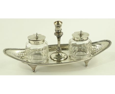 An oval silver desk stand with central taper stick and cut-glass inkwells, Sheffield 1899, length 26cm.