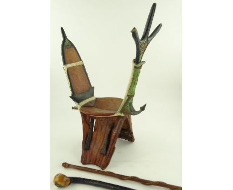 A North African leather and hide mounted camel saddle, a South African Xosa carved wood stick and 1 other, (3).