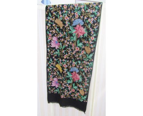A black wool shawl with crewel work floral decorations in vivid colours, a turquoise silk shawl with metal braid border, an E