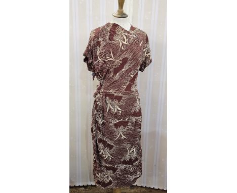 A 1940's brown crepe day dress printed in a cream abstract design with three quarter length sleeves, a frilled detail to the 