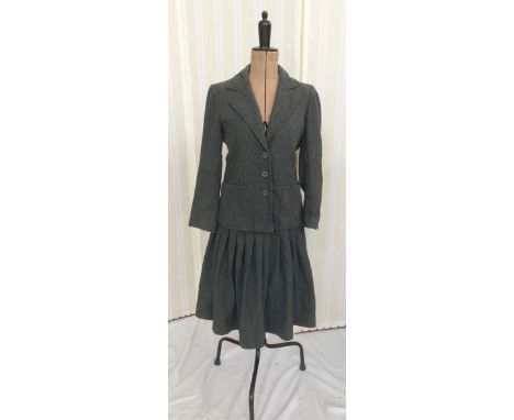 A vintage Hardy Amies grey wool skirt suit, the jacket slightly waisted with pockets to the front, the skirt is fitted, flari