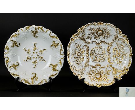 Two Meissen Porcelain Gilt Platters Each of circular form. The first, with serpentine rim, raised on short foot, relief borde