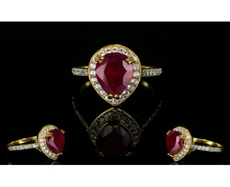 Ruby and Natural White Zircon Ring, a pear cut ruby of 4.25cts framed with .75cts of round cut white zircon set in a 14ct gol