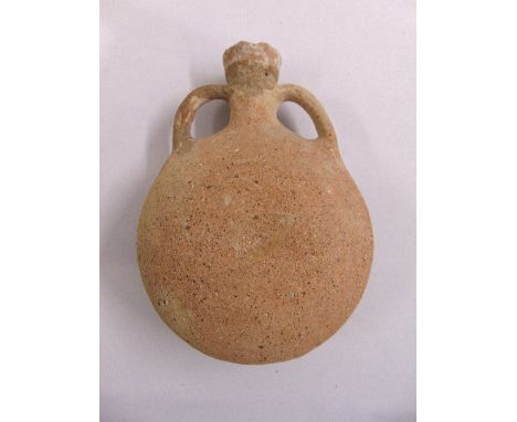 A Roman terracotta water flask of compressed spherical form with two side handles