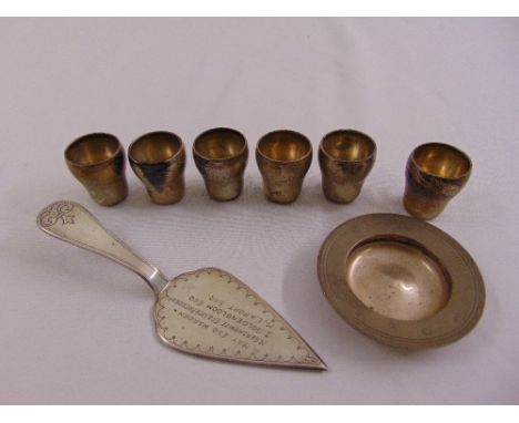 A quantity of silver and white metal to include a presentation trowel and six shot tumblers