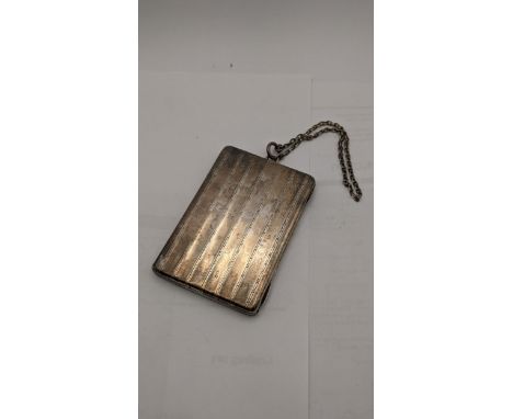An early 20th century silver cigarette case having a gilded interior and silver import marks, on a silver coloured chain 130.
