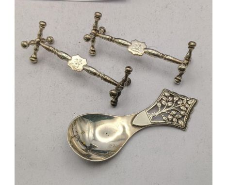 A pair of silver knife rests together with a silver tea caddy spoon hallmarked London 1936, total weight 87gLocation: 