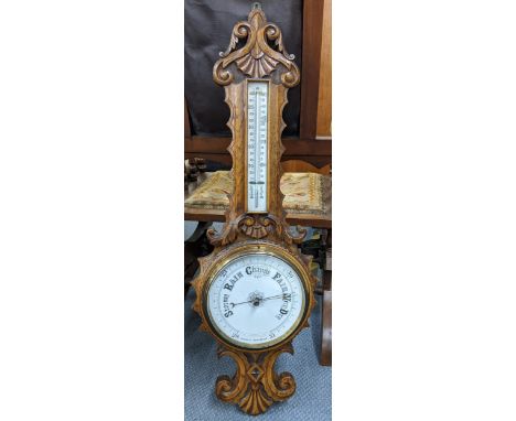 An early 20th century oak carved wall hanging aneroid barometer Location: 