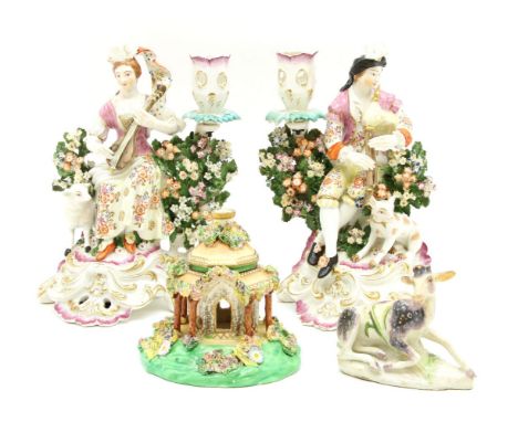 A pair of late 18th century Derby porcelain figures, modelled as a lady and gentleman with instruments and a lamb to their si