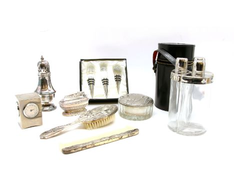 A set of three plated and glass drinks flasks, in a fitted leather case, a three-piece dressing table set, a set of three pla