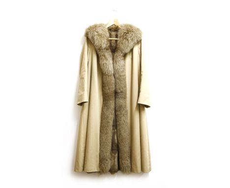 A ladies mink lined mackintosh coat, a cream twill fabric, with a fox fur collar and edging to the front hem, lined in mink w