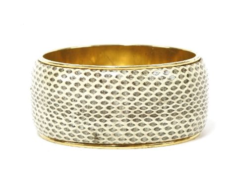 A Dolce and Gabbana snakeskin bangle, cream with dyed black scale pattern, gold-tone interior engraved 'Dolce and Gabbana Mad