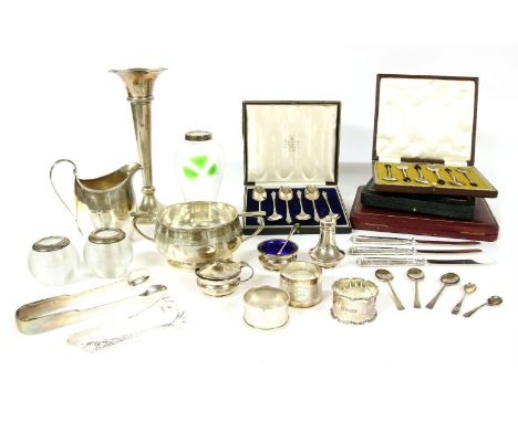 A collection of silver items, to include silver rimmed match strikers, silver napkin rings, cased coffee spoons, a vase, a su