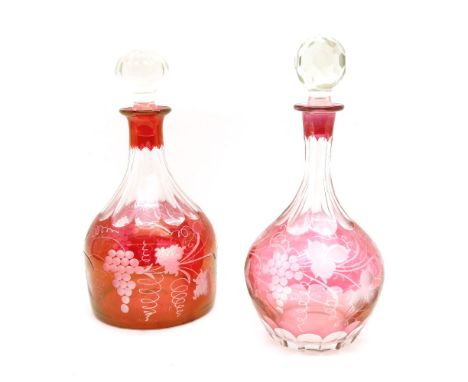 Two ruby flashed decanters, the bodies with wheel cut grape and vine decoration
