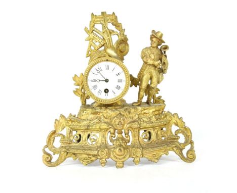 An early 20th Century gilt spelter mantle clock, with pierced panels showing musical motifs and young man holding a horn