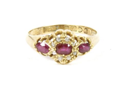 An 18ct gold three stone ruby, and diamond cluster ring (one stone deficient)