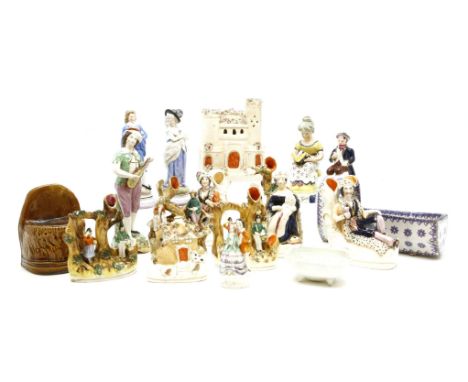 A collection of Staffordshire figures and other items including a pottery cradle, a sash window block and jugs
