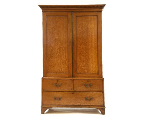 A 19th century oak linen press, as a wardrobe, the dentil cornice over two doors, the base with two drawers and a long drawer