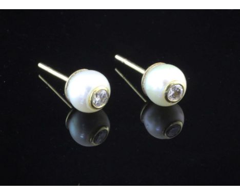 A pair of gold and cultured pearl ear studs, each inset with a round brilliant cut diamond.