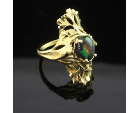 A French 18ct gold and black opal up-finger ring, with oval cut stone and pierced foliate setting, size N.