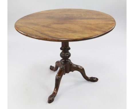 A George III circular mahogany tripod table, with birdcage movement, acanthus carved baluster stem and three leaf carved down