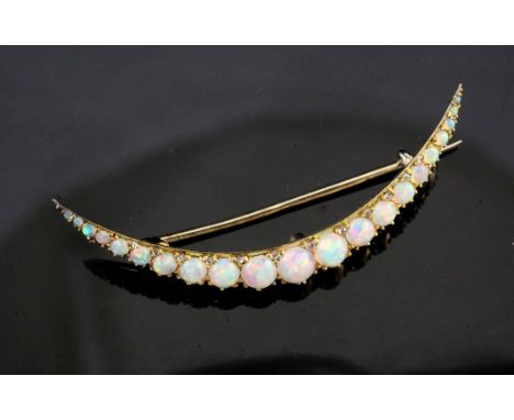 An early 20th century gold and silver, graduated white opal crescent brooch, in gilt tooled leather Goldsmiths & Silversmiths