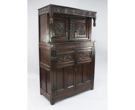 A 17th century carved oak court cupboard, fitted with two doors above a pair of cupboard doors enclosing a single fitted shel