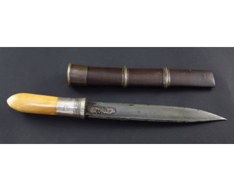 A Burmese dagger or dha, with part floral scrolled inlaid 8 inch blade, with ivory handle, silver mount and brass bound scabb