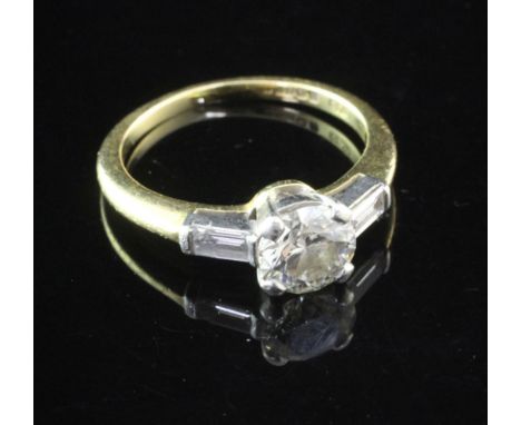 An 18ct gold and platinum single stone diamond ring with baguette cut diamond set shoulders, with insurance valuation dated 1