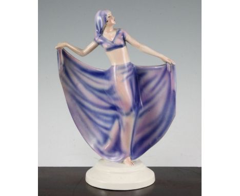 Josef Lorenzl for Goldscheider. An Art Deco figurine of a dancer, wearing a pink and violet head scarf and dress, held aloft 