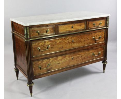 A Directoire brass mounted acajou moucheté commode, with marble top and three long drawers between projecting fluted columns 