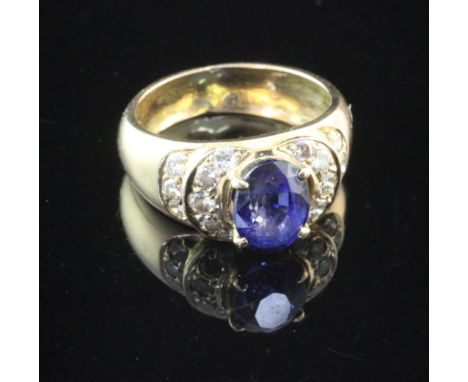 A gold, sapphire and diamond set dress ring, with central oval cut sapphire, flanked by sixteen old cut diamonds, size K.