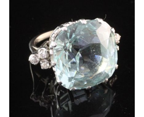 An 18ct white gold, aquamarine and diamond ring, the large fancy cut aquamarine in a raised claw setting and weighing approxi