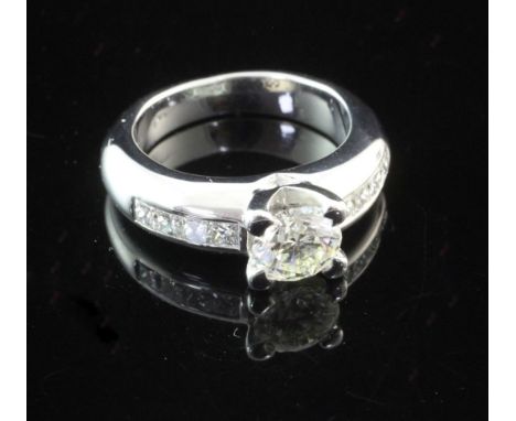 An 18ct white gold single stone diamond ring, with diamond set shoulders, the central stone weighing approximately 1.00ct, si