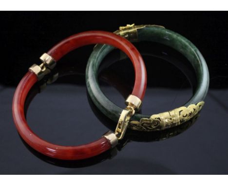 A gold mounted jadeite hinged bangle, with pierced scroll mounts, together with a gold mounted orange jadeite bracelet.