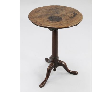 A George III mahogany circular tripod table, with central tapering column and downswept supports with leaf carved decoration,