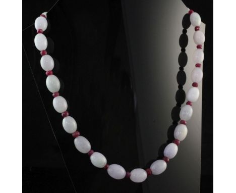 A single strand graduated oval jadeite bead necklace, with facet cut ruby bead spacers, 18in.