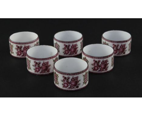 A set of six late 19th century enamel on copper circular napkin rings, decorated with peacocks and flowers and gilded cartouc